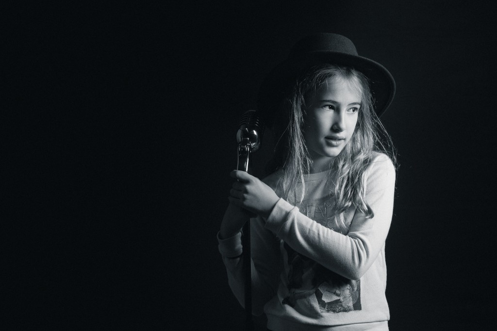 Girl posing with old fashion microphone in black & white